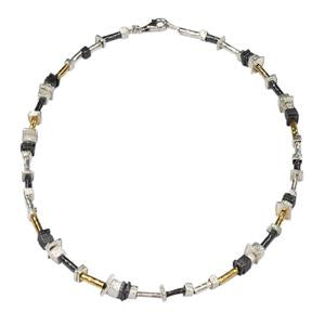 Necklace with black, gold, and silver beads on a white background