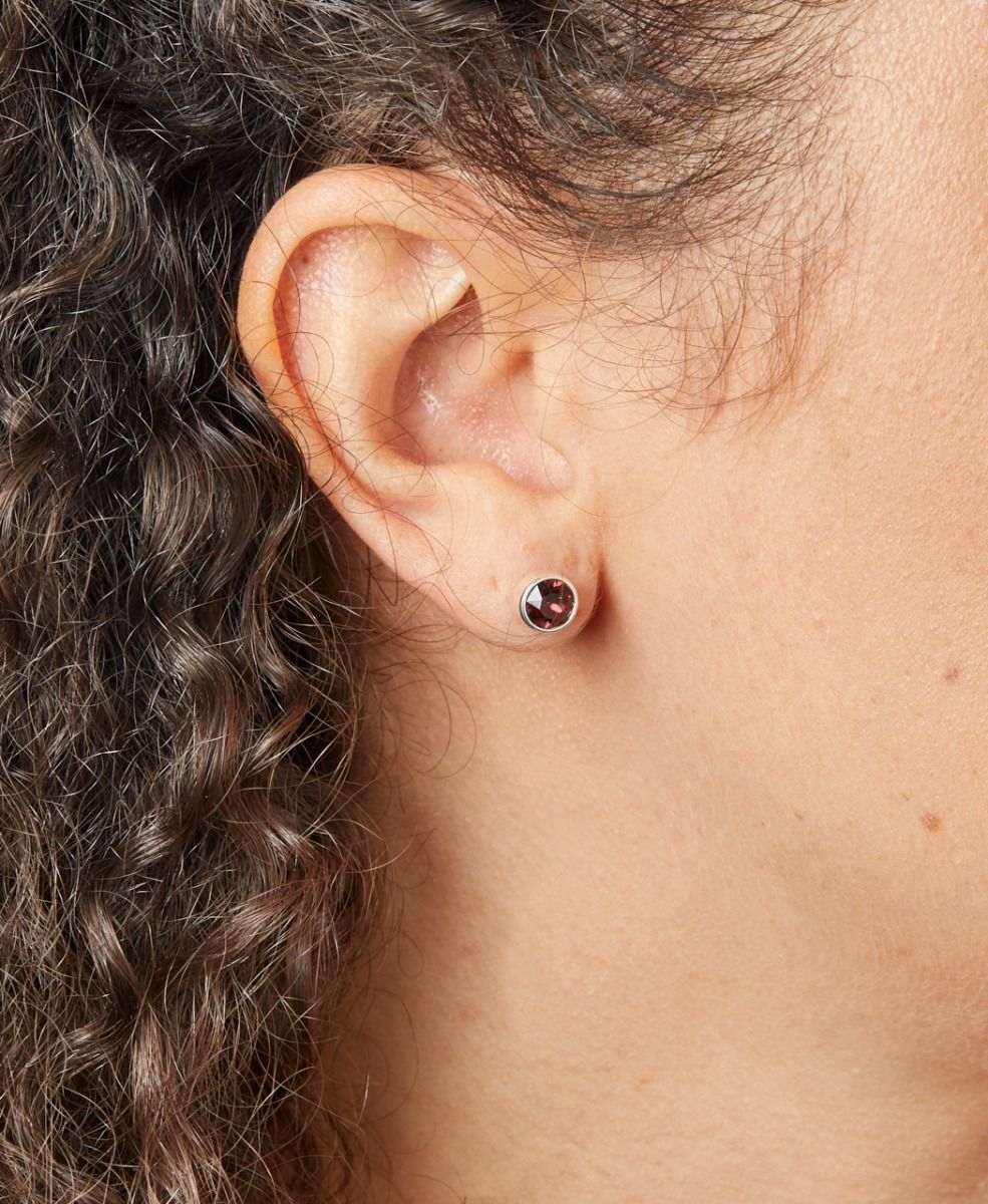 Close-up of an ear wearing a stud earring with a blurred background