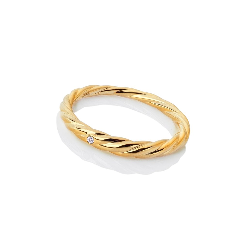 Gold and white ceramic ring with a small diamond on a white background