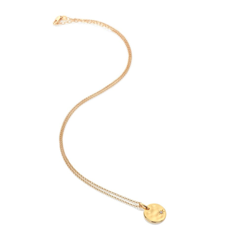 Gold necklace with a small round pendant on a white background