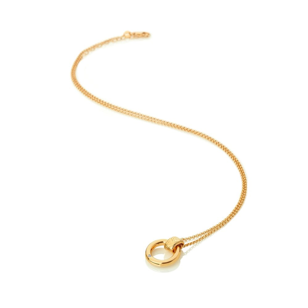 Gold necklace with a circular pendant on a white background