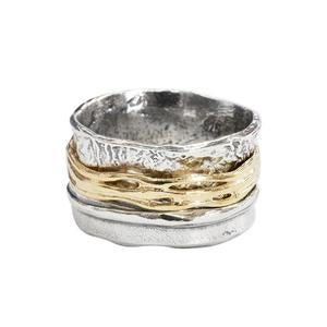 Two-layered ring with silver and gold bands on a white background