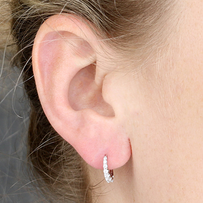 Sterling Silver Graduated Cubic Zirconia Huggie Earrings shown in an ear